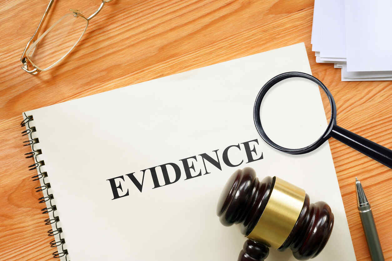 Magnifying glass and gavel on 'EVIDENCE' document, symbolizing USCIS Request for Evidence legal help.