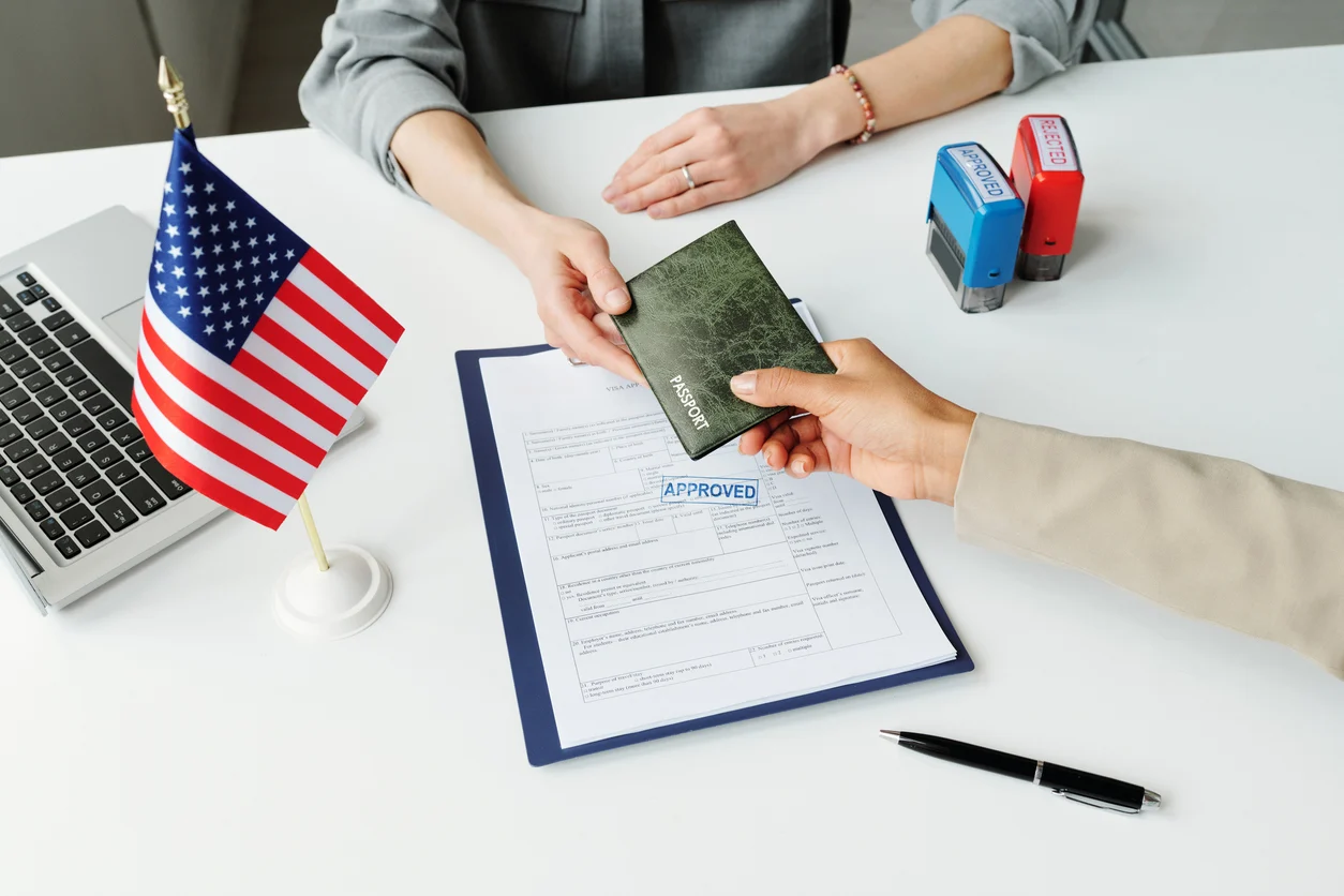 Immigration official approving K-1 visa application with passport and stamped documents, representing the next steps after arriving in the U.S. on a K-1 visa.